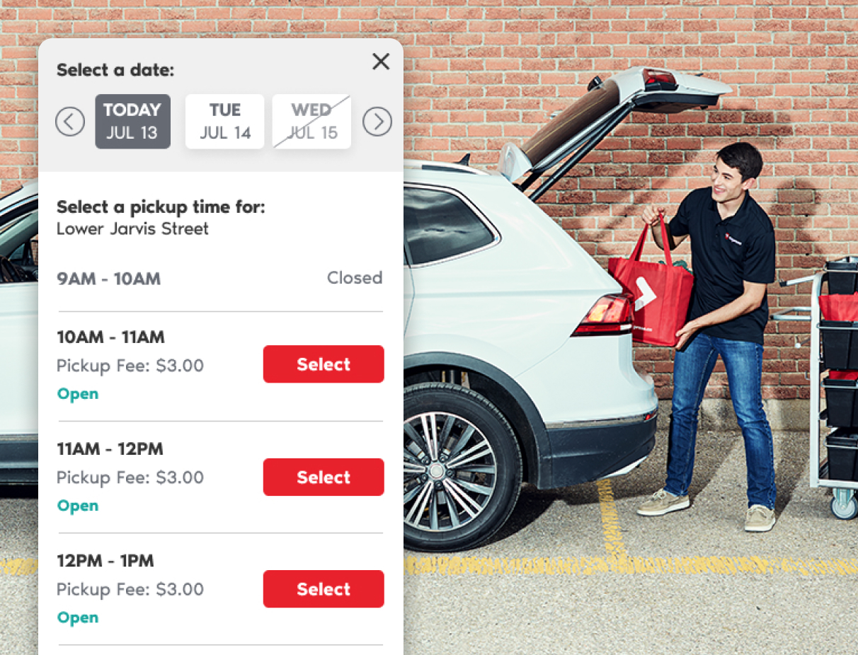 A phone screen displays the timeslot selector for PC Express with the available times for July 13th date. The background behind the phone screen displays a man loading groceries into the back of a car